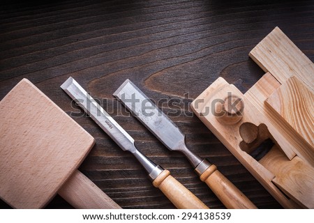 Lump hammer planer flat chisels and wooden bricks on brown background construction concept.