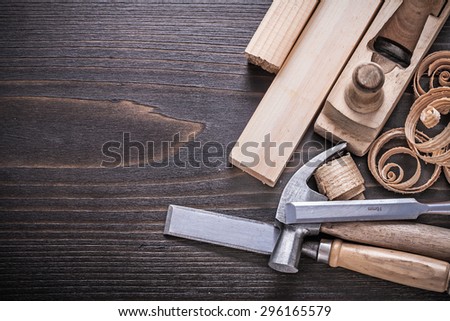 Planer claw hammer metal chisels wooden studs and curled shavings on vintage wood board construction concept.
