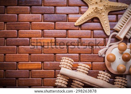 Starfish wood massagers and bath brush on textured wooden table mat sauna concept.