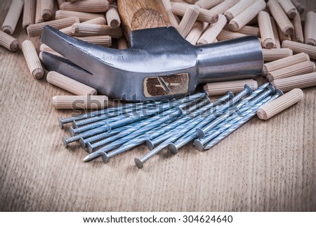 Woodworking dowels nails claw hammer on wooden background.