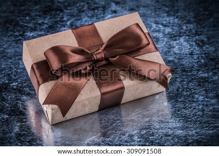 Gift box with present tape on metallic background holiday concept.