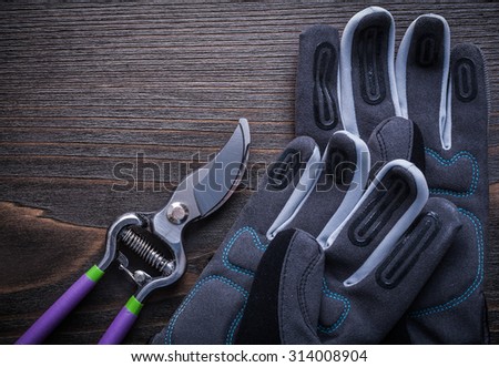Set of garden pruner protective gloves on vintage wood board.