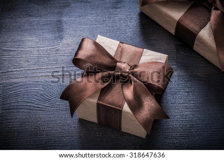 Present boxes with tied ribbons on wood board holiday concept.