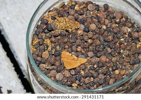 Glass jar filled with the black peppercorn and spices