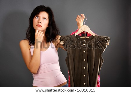 woman is deciding which dress to buy