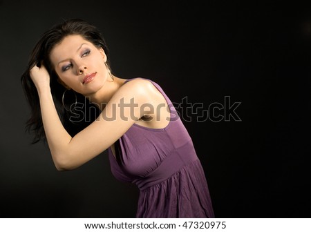 Fashion studio shot of young and beautiful woman wearing lilac dress and dancing