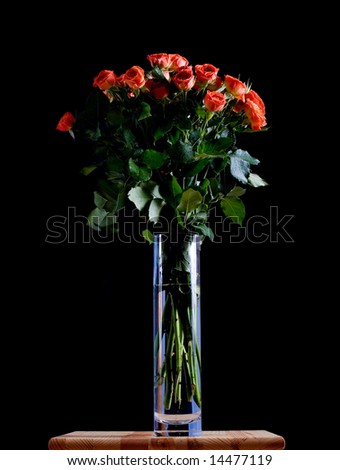 Beautiful wet roses in a blue vase on black background