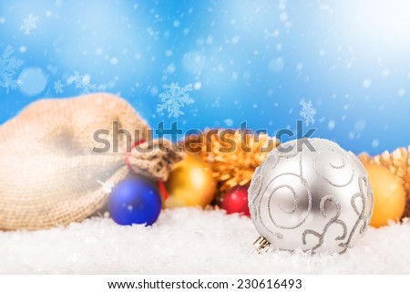 Christmas balls and Santa`s pack on the snow.