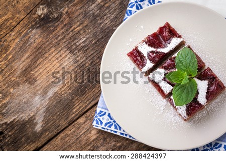 sliced piece of plum cake with cocoa sprinkled with sugar