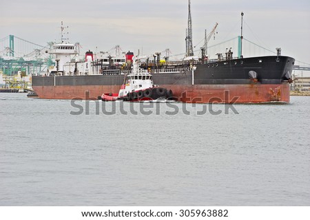 LOS ANGELES/CALIFORNIA - USA: AUGUST 6, 2015:  A heavy-lift marine vessel is escorted by a tug boat out of the harbor. The largest port in the U.S. Port of Los Angeles in San Pedro, California USA