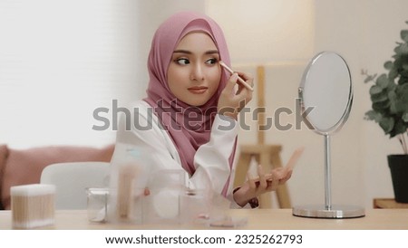 Similar – Image, Stock Photo A young woman makes a snow angel lying in the snow with her arms and legs spread to the sides