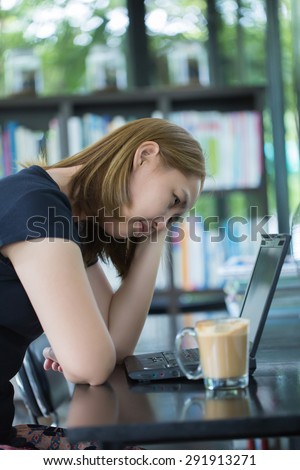 Stressed working Asian woman have a coffee at cafe
