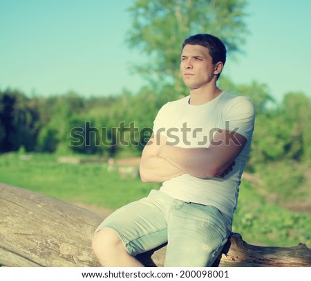 Handsome man enjoying sunset, soft sunny evening light, man pensive looks away