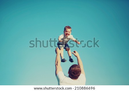 Vintage colors photo happy father and child having fun outdoors, carefree, blue sky, family, travel, vacation, childhood, father\'s day - concept