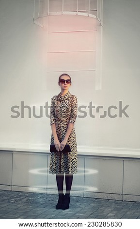 Fashion, technology, future and people concept - stylish futuristic woman in leopard dress with clutch teleported
