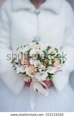 Bride, winter wedding bouquet in hands of the bride closeup