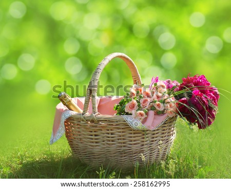 Romance, love and valentine\'s day concept - sweet basket with bouquet of flowers on the grass. Spring fresh relax background