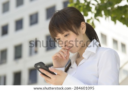 A sad or anxious woman falls to look at the mobile phone