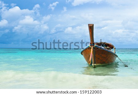 Big wood boat and blue sea under cloudy sky