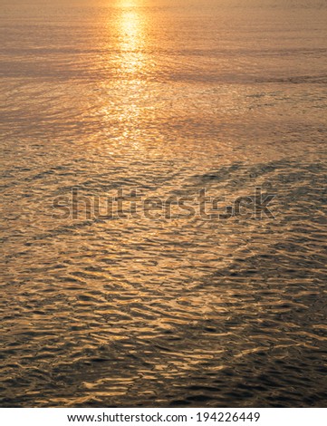 Golden surface of sea before sunset