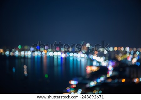 Out of focus sea bay and building in night time
