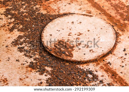 Cicle metal cover on rusty plate background