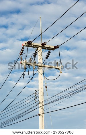Electricity cable and big post under cloudy sky