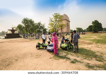 NEW DELHI, INDIA - AUGUST 4: The children and parents are interesting about mini motor car for rent  at the public park around  Indian gate in summer in New Delhi,India on August 4, 2015.