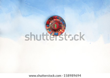 Card with a cup and a saucer smudged with paint on a white and blue background