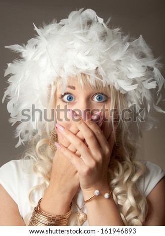 Surprised woman with big blue eyes and a plume hat
