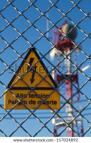 Signal of danger of death metal grille fence of electrical distribution center with communications tower
