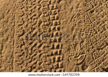 Rolled geometric footprints of vehicles and human footprint on dusty dirt road