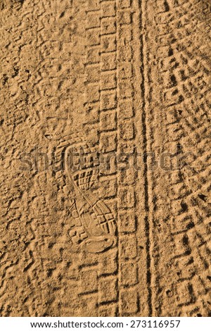 Shot in Road Earth  - Rolled geometric footprints of vehicles and human footprint on dusty dirt road