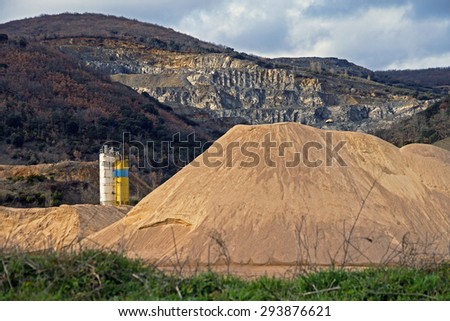 Pierced mountain quarry for stone quarrying and sand. Sand Mountain gravel pit in the foreground in silos