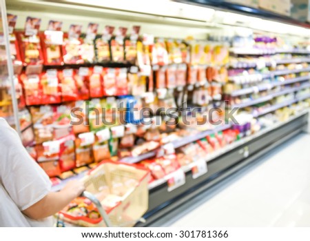 blurred image of supermarket people shopping - product shelf - business concept