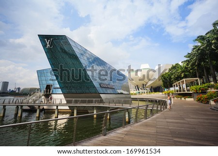 SINGAPORE - JAN 2: The futuristic building housing Louis Vuitton store mirrors on the quiet waters of Singapore bay circa JAN 2, 2014 in Singapore.