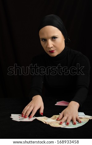 Woman in black with playing cards and money