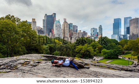 NEW YORK - SEPTEMBER 22: A man sleep in Central Park on September 22, 2011 in New York City. Central Park is a public park at the center of Manhattan in New York City.