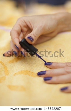 Woman applying purple nail polish