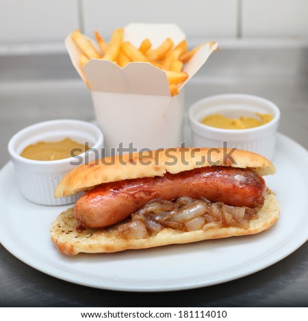 Debrecen sausage, hot dog with french fries and mustard sauce on plate, fast food menu