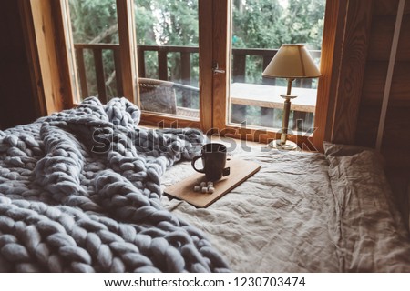Rustic interior decoration of log cabin bedroom. Cozy warm blanket on bed by window. Сток-фото © 