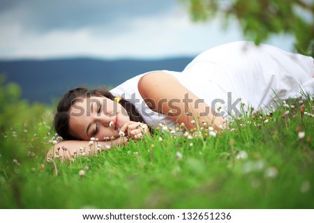 Casual outdoor portrait of young beautiful woman resting at spring nature