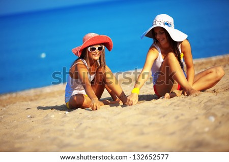 Beautiful young girls resting at the beach in hot summer