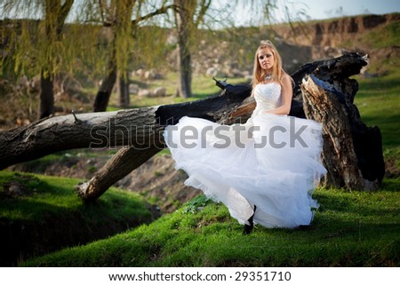 Bride wearing beautiful wedding dress posing in action outdoors