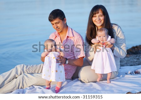 Happy young parents with infant children over sea
