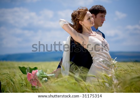 Wedding couple embracing in eared field