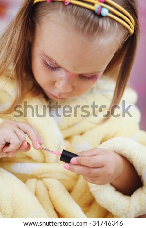 Little girl playing with cosmetics of her mother at home
