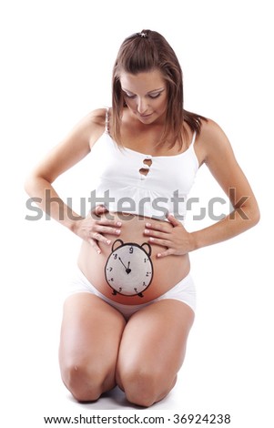 Conceptual image of pregnant female with painted clock on her belly