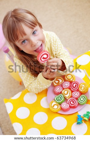 Cute child eating candies at home