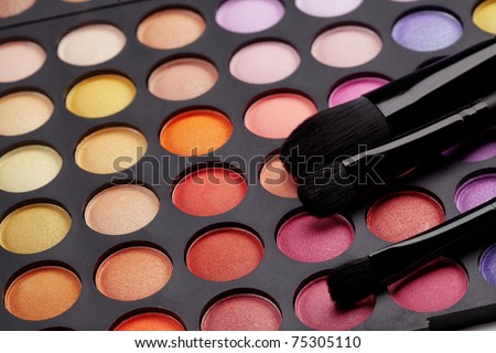 Make-up colorful eyeshadow palette with makeup brushes on it